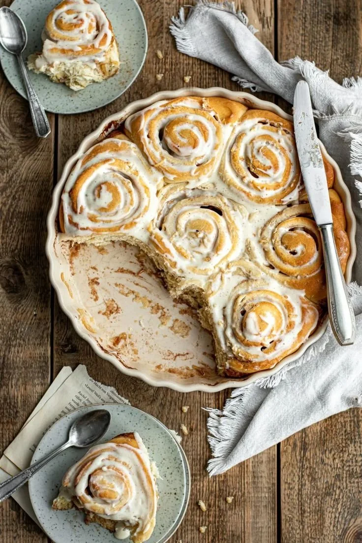 Apfelzimtschnecken mit Butter Honigfrosting auf einem Teller serviert.