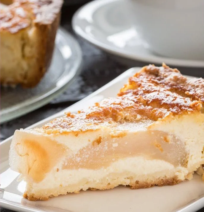 Saftiger Birnen-Pudding-Kuchen mit Crème fraîche auf einem Teller