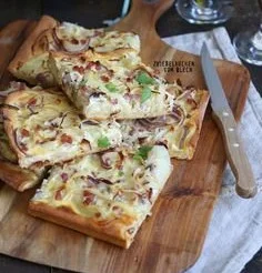 Einfacher Zwiebelkuchen vom Blech auf einem Holzbrett serviert