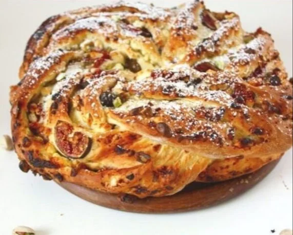 Hefekranz mit Feigen, Pistazien und Feta auf einem Teller angerichtet