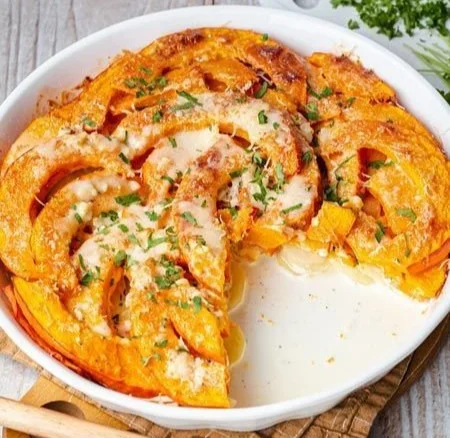 Leckeres und cremiges Kartoffel-Kürbis-Gratin in einer Auflaufform.