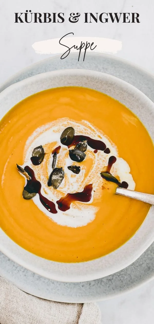 Kürbis Ingwer Suppe in einer Schüssel, garniert mit Kräutern und einem Löffel