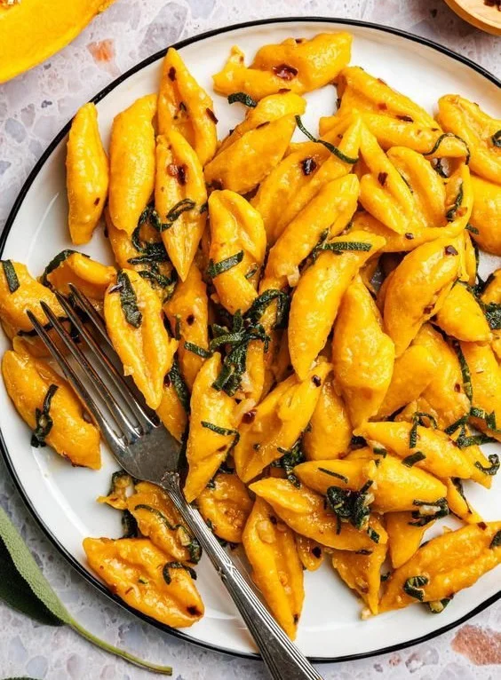 Leckere Kürbis-Scherennudeln mit Salbei, Knoblauch und Chili angerichtet.