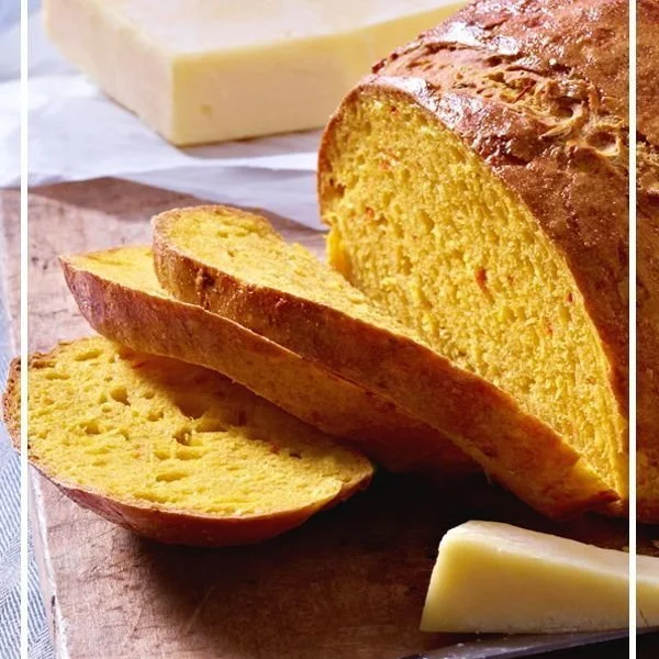 Hausgemachtes Kürbisbrot mit Gewürzen und Nüssen auf einem Holzbrett.