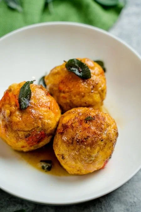 Leckere Kürbisknödel auf einem Teller, ideal für Herbstgerichte.