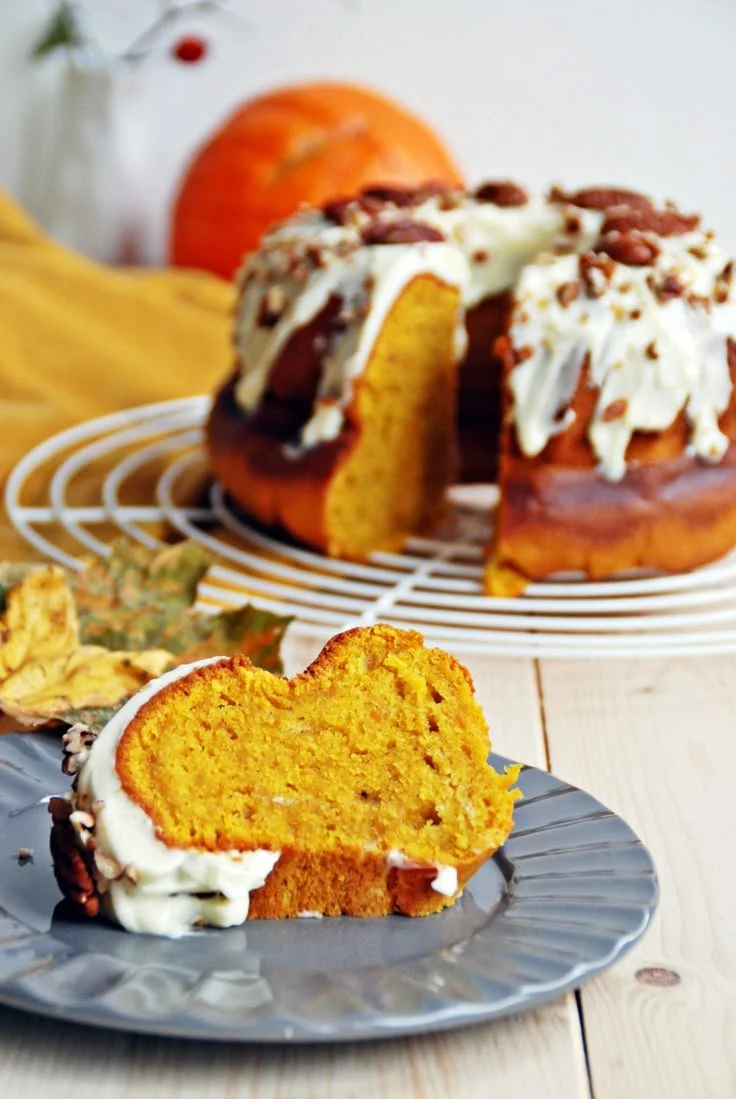 Leckerer Kürbiskuchen mit Frischkäse Frosting präsentiert auf einem Tisch.