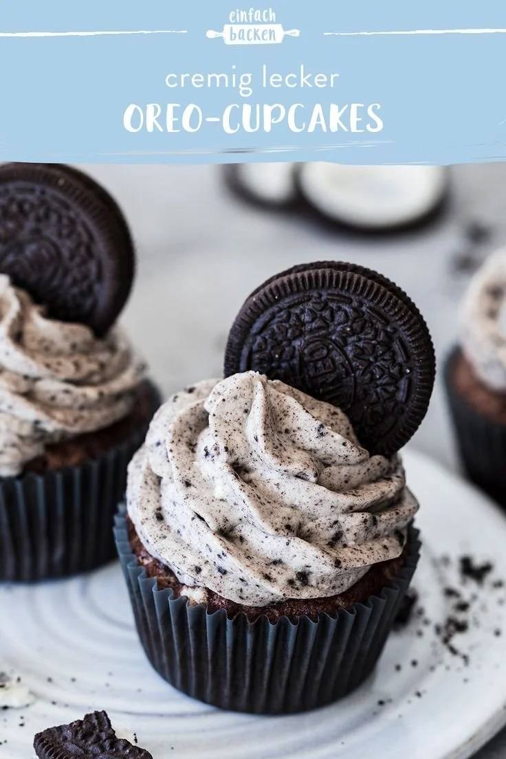 Oreo-Cupcakes auf einem Teller, dekoriert mit Sahne und Oreo-Stücken.