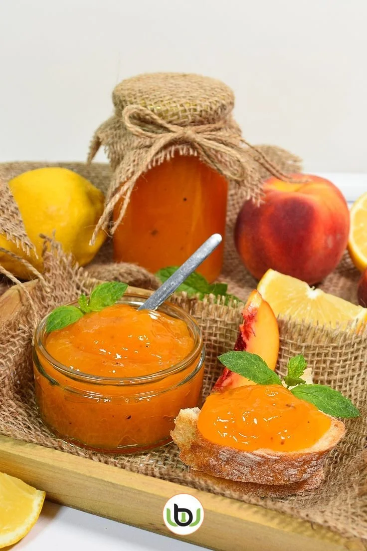 Pfirsichmarmelade mit Tonkabohnen in einem Glas, dekoriert mit frischen Pfirsichen