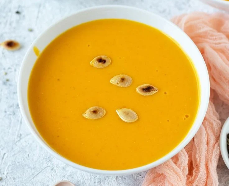 Kürbissuppe mit Kartoffeln und Möhren in einer dekorativen Schüssel