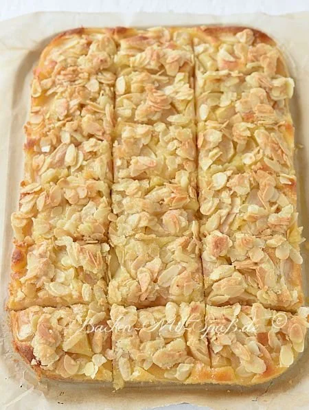 Saftiger Apfelkuchen mit Mandelkruste auf einem Holzbrett