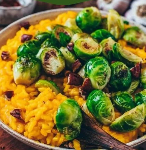 Veganes Kürbis-Risotto mit Rosenkohl im herbstlichen Dekor.