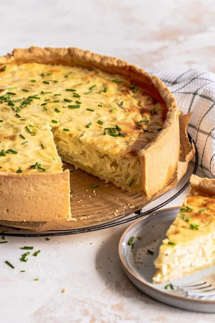 Vegetarischer Zwiebelkuchen mit frischen Zwiebeln und Kräutern auf einem Teigboden