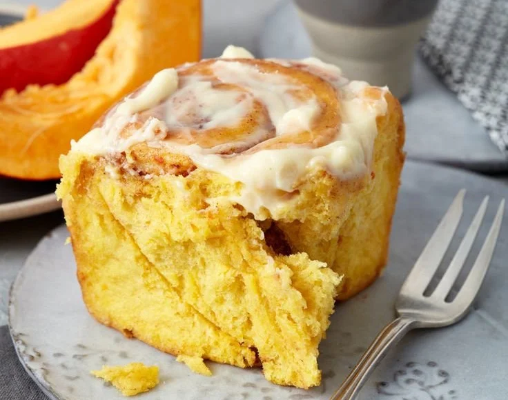 Zimtschnecken mit Kürbis und Frischkäse-Frosting auf einem Teller
