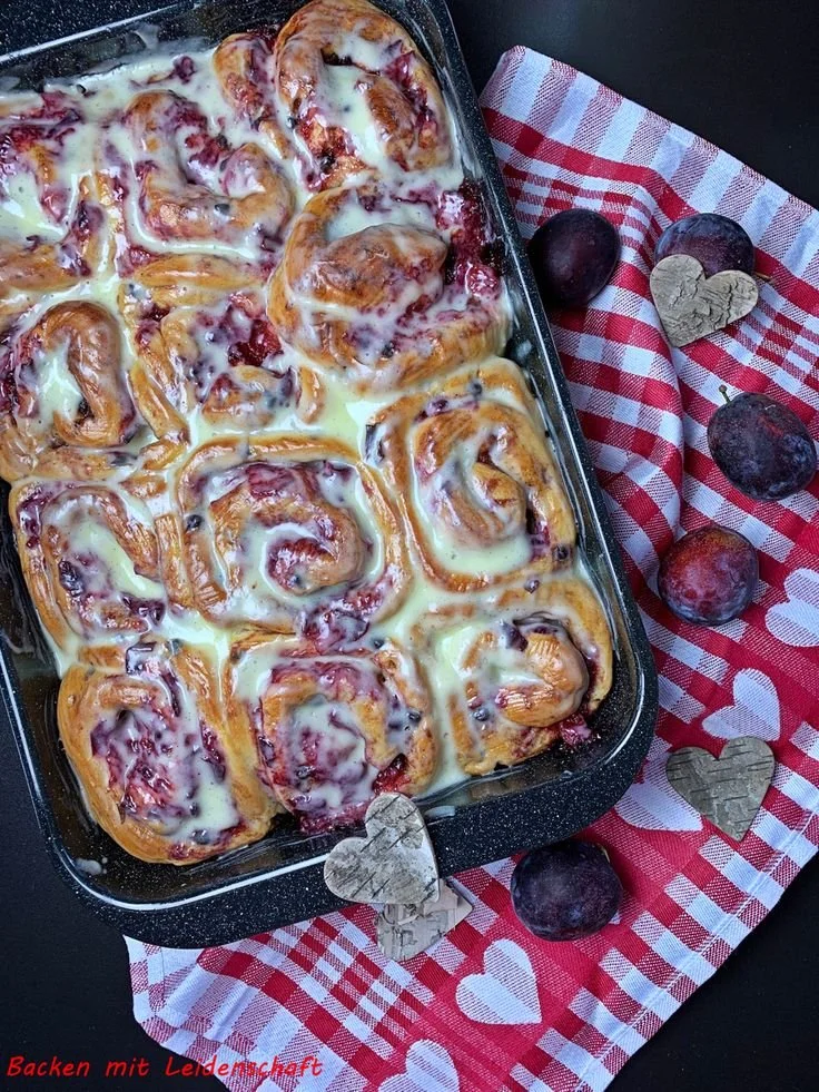 Leckere Zwetschgen-Zimtschnecken mit Schokolade auf einem Backblech