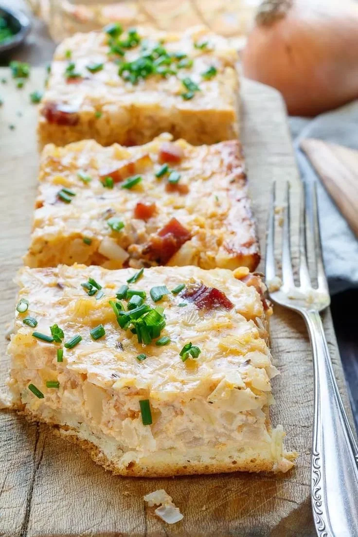 Zwiebelkuchen vom Blech auf einem Tisch, bereit zum Servieren