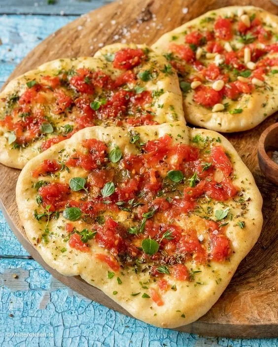 Fladenbrot mit Tomaten und Knoblauchbutter, extra knusprig serviert.