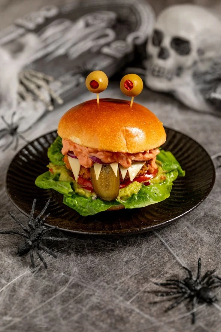Monster Burger für Halloween mit Fleisch und bunten Zutaten auf einem Teller